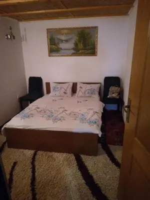 a bedroom with a bed with two chairs in it at Vikendica Amra i Indir in Travnik