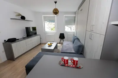 a living room with a table with red cups on it at Apartman Skver in Tuzla