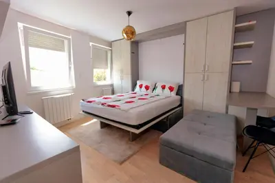 a bedroom with a bed and a desk and a desk at Apartman Skver in Tuzla