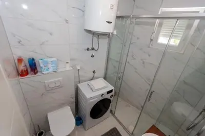 a small bathroom with a shower and a toilet at Apartman Skver in Tuzla