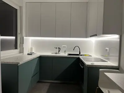 a kitchen with white and green cabinets and a sink at Apartman EMA in Banja Luka