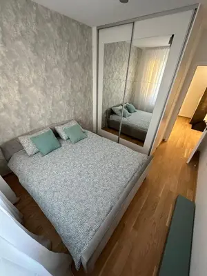 a bedroom with a bed and a mirror at Apartman EMA in Banja Luka