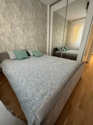 a bedroom with a large bed with a mirror at Apartman EMA in Banja Luka