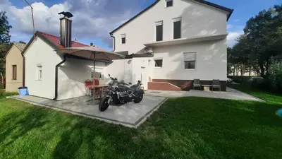 a motorcycle parked in front of a white house at 7 Kućica in Livno