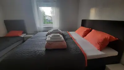 a bedroom with a large bed with orange pillows at 7 Kućica in Livno