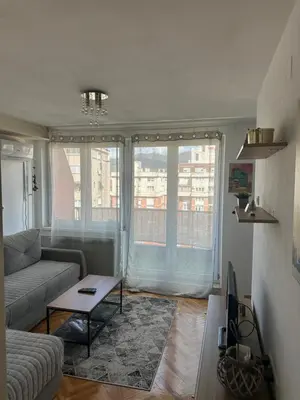 a living room with a couch and a table at Apartman Nira in Zenica
