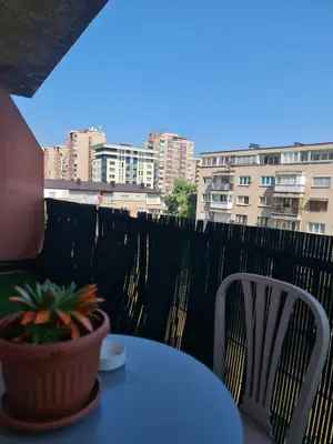 a table and chairs on a balcony with a potted plant at Apartman Nira in Zenica