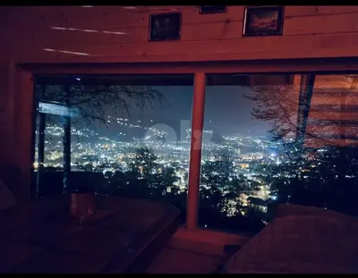 a view of a city at night from a window at Vikendica VIDIKOVAC na Piramidi Sunca in Visoko