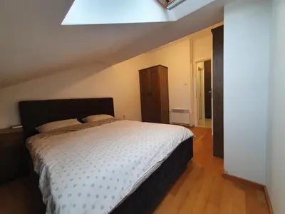 a bedroom with a large bed with a skylight at Apartman RedBrick in Banja Luka