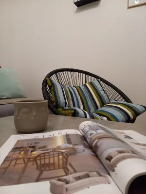 a book on a table with a chair and a couch at Apartman RedBrick in Banja Luka