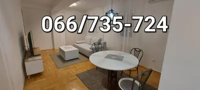 a living room with a white table and a tv at Apartmani ANNA in Banja Luka