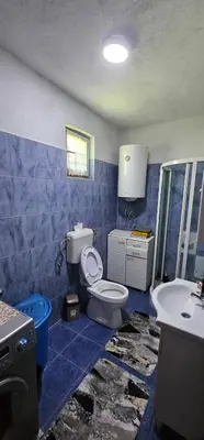 a blue and white bathroom with a toilet and a sink at Apartman Hushida in Bihać