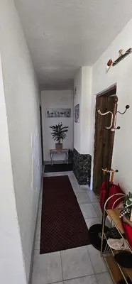 a hallway with a room with a door and a rug at Apartman Hushida in Bihać
