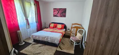 a small bedroom with a bed and a chair at Apartman Hushida in Bihać