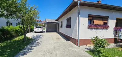 a white car parked next to a house at Apartman Hushida in Bihać