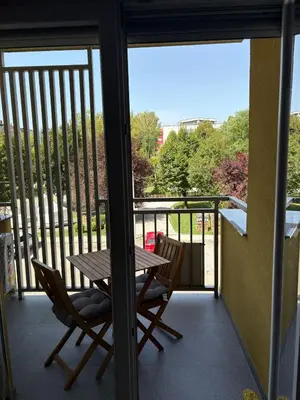 a balcony with a wooden table and two chairs at Apartman VIVA in Bihać