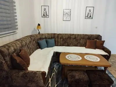 a couch with a table in a living room at Apartman Sandi in Novi Travnik