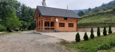 a wooden cabin in a field with a gravel driveway at Eko kuca Jandro in Šipovo