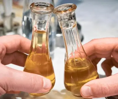 two glass vases filled with yellow liquid sitting on a table at Eko kuca Jandro in Šipovo