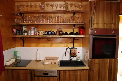 a kitchen with a sink and shelves with glasses at Eko kuca Jandro in Šipovo