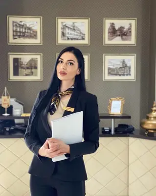 a woman in a suit holding a piece of paper at Hotel Banja Luka in Banja Luka