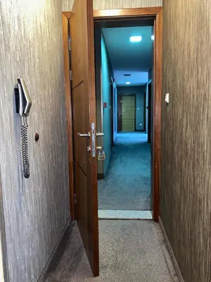 a hallway with a door and a phone on the wall at Hotel Banja Luka in Banja Luka