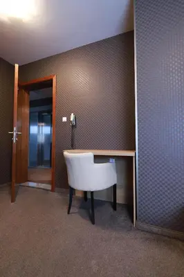 a room with a white chair and a desk at Hotel Banja Luka in Banja Luka