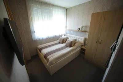 a small bedroom with a bed and a window at Hotel Banja Luka in Banja Luka