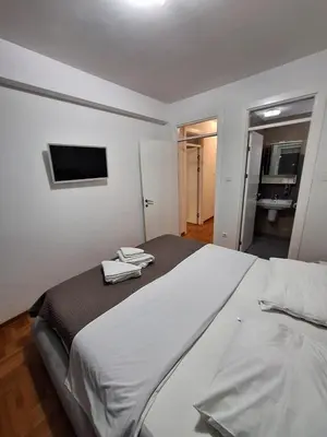a bedroom with a large bed with a tv on the wall at PENTHAUS apartment in Banja Luka