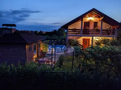 a house with a light on the side of it at Wisteria Lodge in Derventa