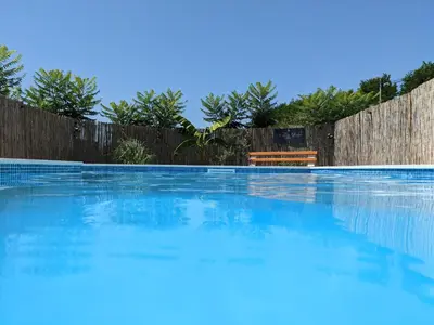 a swimming pool in front of a wooden fence at Wisteria Lodge in Derventa