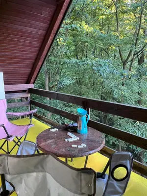 a table and chairs on a porch with a window at ALBAK Green Zone in Gradačac