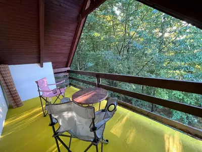 two chairs and a table on a porch with a large window at ALBAK Green Zone in Gradačac