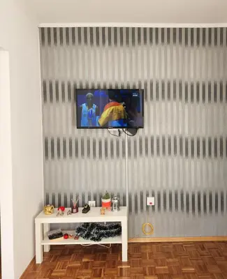 a living room with a tv on a wall at Stan na dan Nova Varoš in Banja Luka