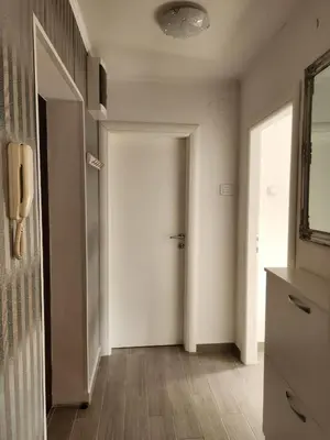 a hallway with a white door and a mirror at Stan na dan Nova Varoš in Banja Luka