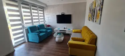 a living room with a yellow couch and blue chairs at LARA S in Banja Luka