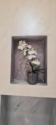 a vase of white flowers sitting on a shelf at LARA S in Banja Luka
