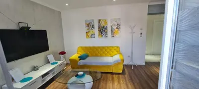 a living room with a yellow couch and a tv at LARA S in Banja Luka