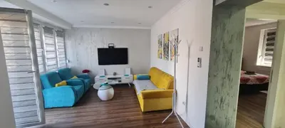 a living room with blue and yellow chairs and a tv at LARA S in Banja Luka