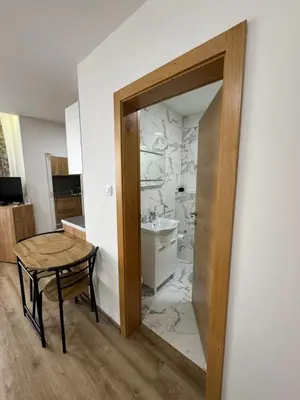 a bathroom with a toilet and a sink and a table at Aparmani Karanovic in Zavidovići