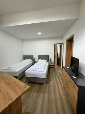 a room with two beds and a flat screen tv at Aparmani Karanovic in Zavidovići