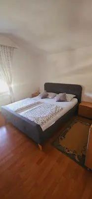 a large bed in a bedroom with a wooden floor at Apartman GOGO in Livno