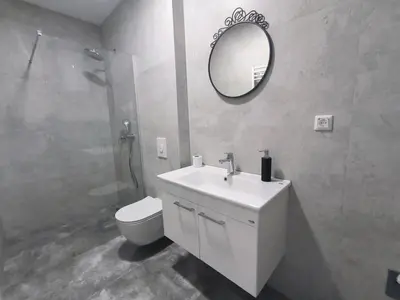 a bathroom with a sink and a toilet and a mirror at Kupres, centar, apartman in Kupres