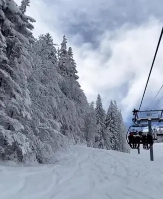 a ski lift with snow covered trees on a ski slope at Kupres, centar, apartman in Kupres