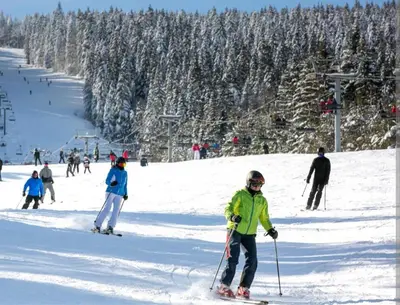 a group of people skiing down a snow covered slope at Kupres, centar, apartman in Kupres