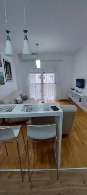 a living room with a table and chairs and a couch at Alexandra apartment in Banja Luka