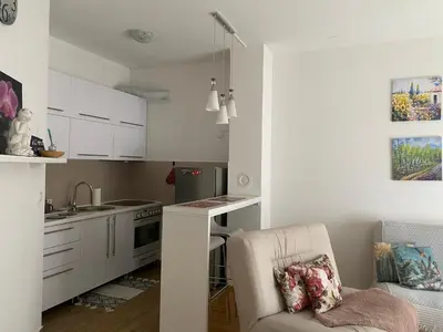 a small kitchen with white cabinets and a chair at Alexandra apartment in Banja Luka