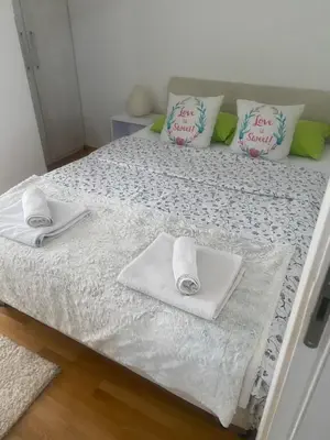 a bed with two towels and two pillows on it at Alexandra apartment in Banja Luka