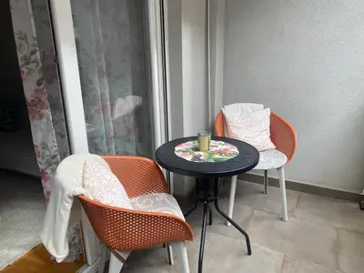 a small table with two chairs and a candle on it at Alexandra apartment in Banja Luka