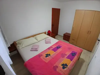 a bedroom with a bed with a colorful blanket on it at Stan na dan Apartman Kozarac in Kozarac